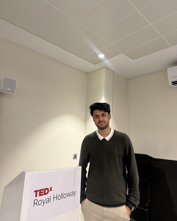 Muhammad beside the TEDxRoyalHolloway lectern.